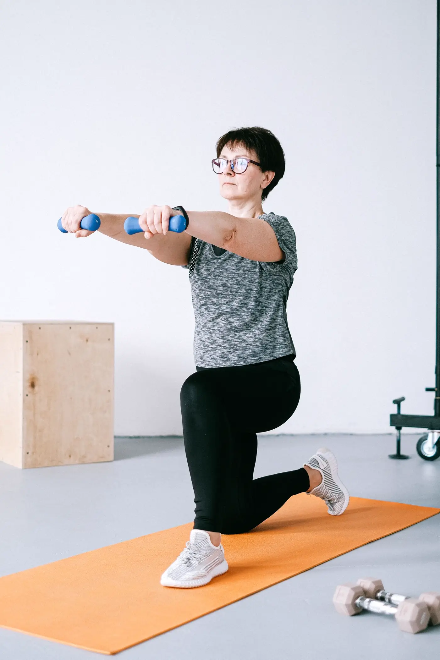 Mulher treinando com halteres em casa